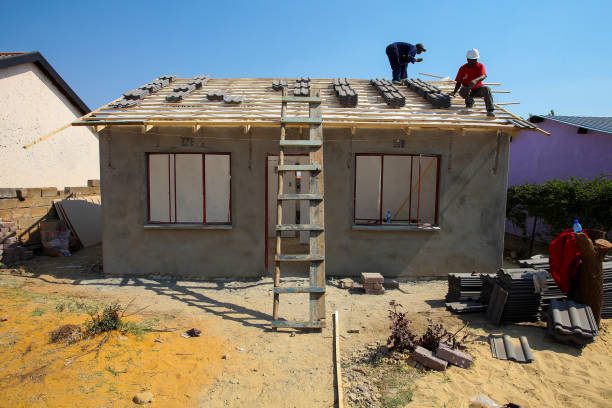 istockphoto-970281626-612×612 Soweto, South Africa, September 10, 2011, Diverse Community members building a low cost house as a team in Soweto